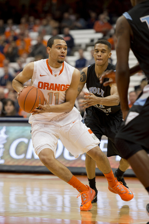 Syracuse guard Tyler Ennis cuts away from a pair of defenders in the Orange's scrimmage against Division III Holy Family (Pa.) University.