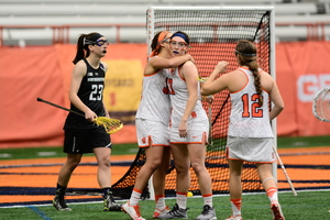 Three Syracuse celebrates a goal in front of Northwestern's crease. A 5-0 run by the Orange in the second half helped it stay undefeated on the season. 