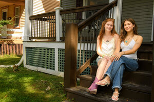 Anjali Engstrom, right, and Romy VanAlmen, Sage Haus creators, sat on their front stoop Sunday. Sage Haus is a new house show venue that mixes outdoor daytime shows with second-hand shopping.