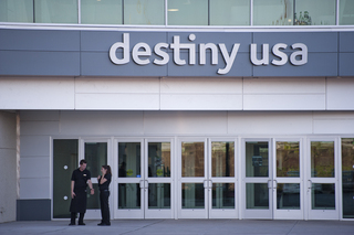 Workers wait outside one of the entrances.