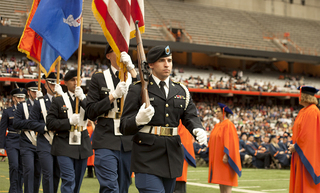 The American flag is brought into the Carrier Dome before the national anthem during the 2013 commencement ceremony.