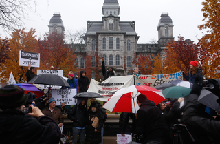 Protestors with fabric posters cheer outside of the Hall of Languages to rally support for THE General Body.