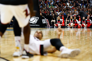 The N.C. State cheerleaders look on while a Louisville player is helped up by a teammate.