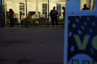 Voters wait in line outside Huntington Hall while poll workers attempt to fix the ballot printer inside.