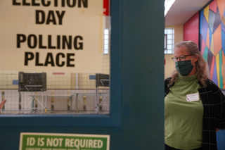 Kate Saufley, the election inspector at Erwin First United Methodist Church, waits at the entrance to the polling location to point voters to the voter receipt booth.