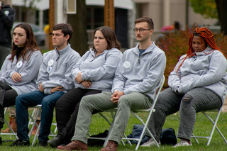 Remembrance Scholars Mackenzie Quinn, Ronald Ditchek, Mira Berenbaum, Adam Landry and Ofentse Mokoka sit in reflection on Shaw Quadrangle during the event. Some scholars wore pins with the face of the Pan Am Flight 103 victim they represent. 