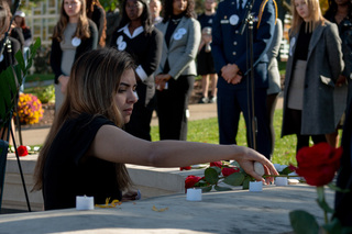 Maggie Sardino, another member of the 2022 Remembrance cohort, places a rose in honor of Alexia Tsairis. Her and others' roses are placed for all other people who lost their lives in the bombing.
